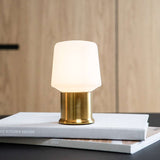 Gouden Ambience lampvoet van sackit Netherlands met zachte witte lampenkap op designboeken voor een warme en stijlvolle sfeer in huis