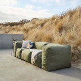 Soft Sofa Outdoor 3 Seater in Kirra Olive van sackit in een ontspannen loungehoek buiten