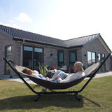 sackit Cobana hangmat met twee ontspannen mensen in een ruime tuin op een zonnige dag