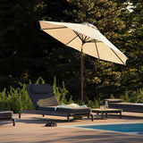 Luxe buitenlounge met ligbedden en parasol naast een zwembad in een groene tuin ingericht voor ontspannen zomerdagen