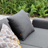 Donkergrijs Cobana kussen en decoratief patroon kussen op een weerbestendige loungesofa van sackit in een groene tuin