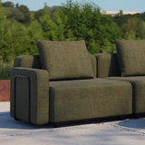 Groene Cobana buitensofa met zachte zit en rugkussens op een terras in een groene tuin ontworpen voor comfortabel buiten zitten