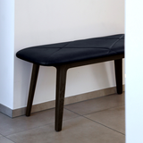 Donker gebeitste eikenhouten bank met zacht zwart leer in een modern interieur van sackit. Tijdloos Deens ontwerp met comfort en verfijnde details