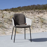 Donkergrijs volledig zitkussen op een witte Patio Chair no. One van sackit buiten in een duinlandschap met helmgras en zandduinen