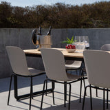 Lichtgrijze tuinstoelen rond een houten buitentafel op een modern terras met glazen en fruit van sackit voor stijlvolle diners buiten