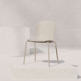 Lichtbeige patio stoel met ergonomische zitting en slank metalen onderstel van sackit op een minimalistisch licht podium in een rustige studioomgeving
