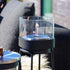 Zwarte patio accessoirehouder van sackit met glazen bio lamp en levende vlam voor een sfeervolle uitstraling binnen of buiten