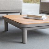 Lage outdoor salontafel met afgeronde hoeken en houten blad van sackit in een moderne zithoek buiten