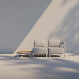 Modulaire grijze loungesofa voor twee personen met houten bijzettafel van sackit voor stijlvol en weerbestendig buitenleven in Scandinavisch design
