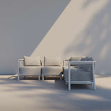 Lichtgrijze modulaire loungesofa van sackit voor buiten met zachte kussens en een architectonisch frame tegen een rustige wand