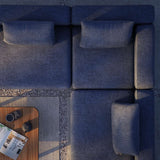 Donkerblauwe modulaire loungebank van sackit met hoekopstelling en losse rugkussens naast een houten bijzettafel op een terras