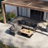 Donkergrijze Kirra loungeset van sackit uit Nederland met modulaire tweezitsbank en fauteuil met houten salontafel op een modern terras onder een pergola