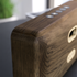 Close up van een houten luidspreker van sackit met bedieningsknoppen en afgeronde details in donker eikenhout voor een stijlvol interieur