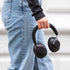 Zwarte Touch 310 over ear hoofdtelefoon van sackit in de hand van een persoon met jeans en zwarte kleding