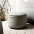 Lichtgrijze Cura pouf van sackit met zachte bekleding en decoratieve stiknaden in een stijlvol Scandinavisch interieur naast een zitzak