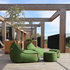Groene Cobana zitzak met twee bijpassende poefs van sackit op een houten terras onder een moderne pergola voor comfortabel buiten zitten
