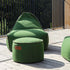 Groene Cobana poef van sackit naast een bijpassende lounge stoel op een houten terras met zwarte houten omheining