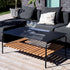 Zwart buiten salontafel van gepoedercoat aluminium met teakhouten onderplank naast een loungebank op een zonnig terras van sackit