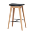 Barkruk van licht massief eikenhout met zwarte leren zitting zichtbare stiksels en zwarte voetsteun van sackit voor een stijlvol Scandinavisch interieur