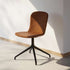 Bruine eetkamerstoel met afgeronde kuipzitting en zwart draaionderstel in modern Scandinavisch design van sackit