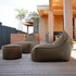 sackit Cobana loungestoelen met bijpassende poef op een houten terras bij een modern buitenverblijf voor comfortabel buiten loungen in Scandinavisch design