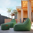 Groene Cobana lounge zitzakken met bijpassende poef op een houten terras bij een modern houten huis van sackit voor comfortabel buiten zitten