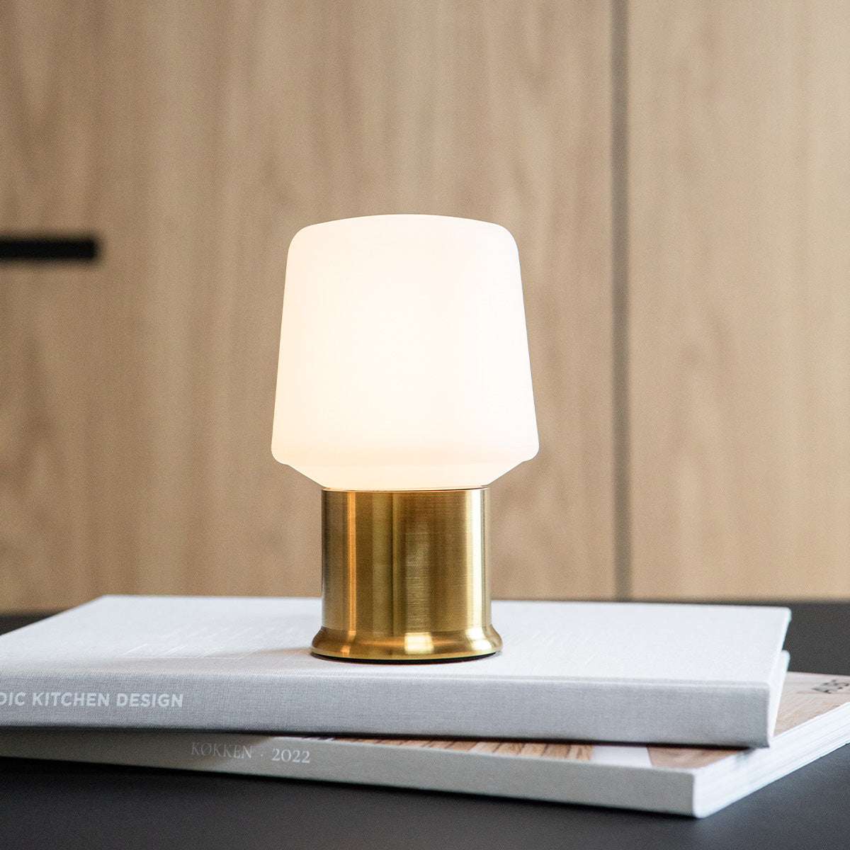 Gouden Ambience lampvoet van sackit Netherlands met zachte witte lampenkap op designboeken voor een warme en stijlvolle sfeer in huis