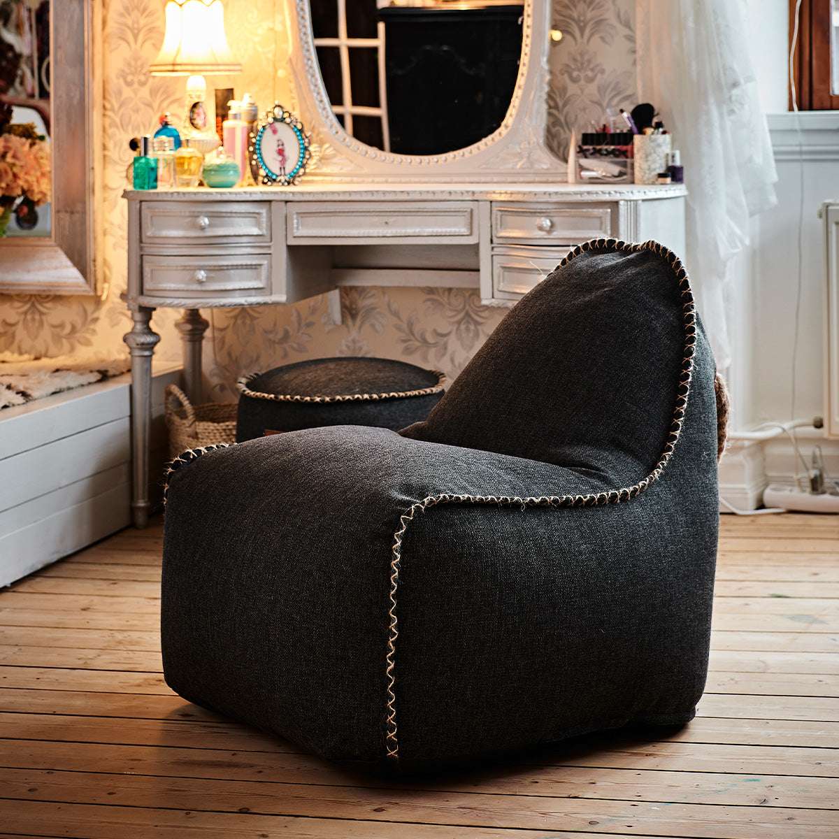 Zwarte sackit Cobana Junior loungestoel in een sfeervol interieur met houten vloer en kaptafel comfortabele zitzakstoel voor binnen en buiten