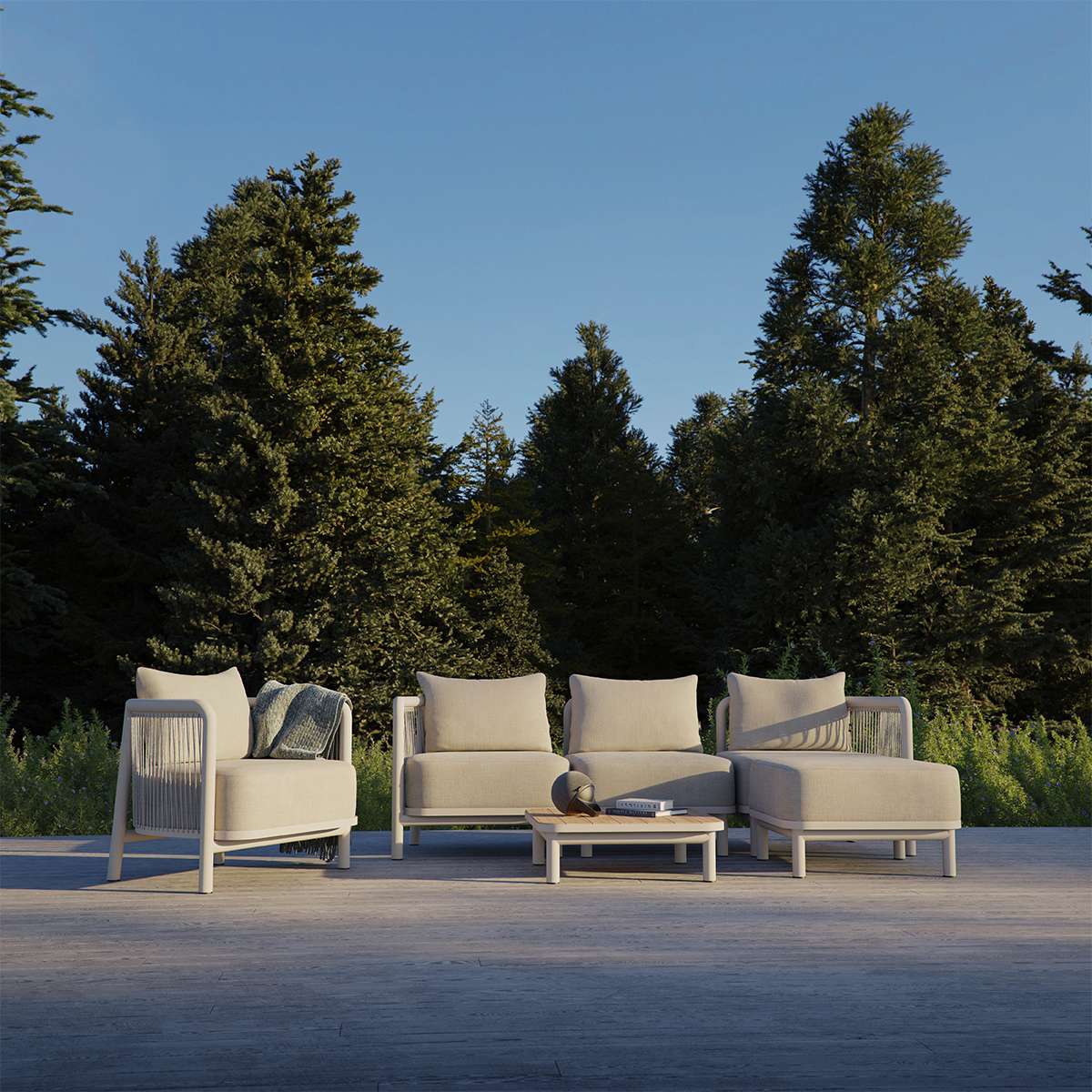 Modulaire Kirra lounge op een terras met beige fauteuils en bankdelen van sackit in een groene bosrijke omgeving met Scandinavisch design
