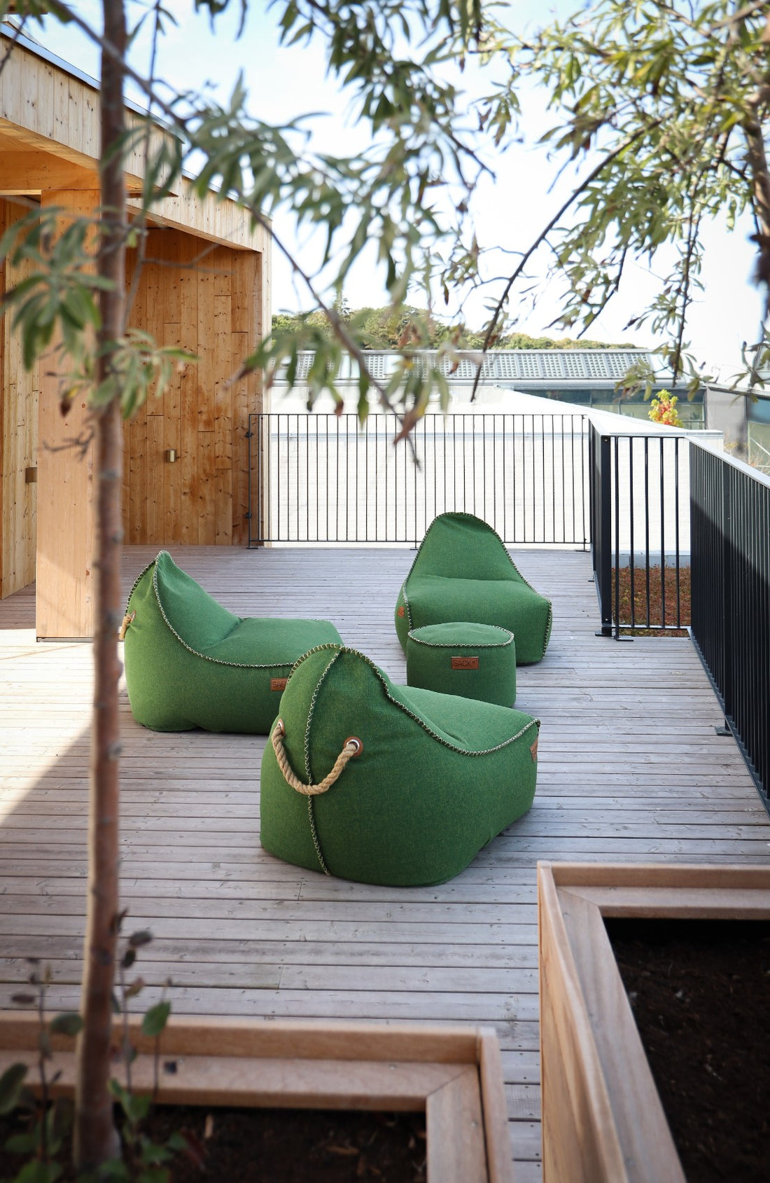 Loungegedeelte met meerdere groene Cobana Lounge Chairs en Poufs van SACKit bij Hotel GSH