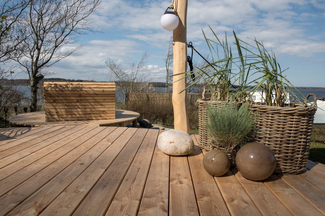 Outdoorlamp Light 150 van SACKit gemonteerd op een paal op het terras bij Mariager Camping & Hytter