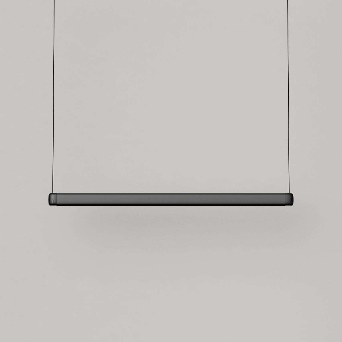 Pebble hanglamp boven de eettafel in zwart van sackit aan, met warm licht