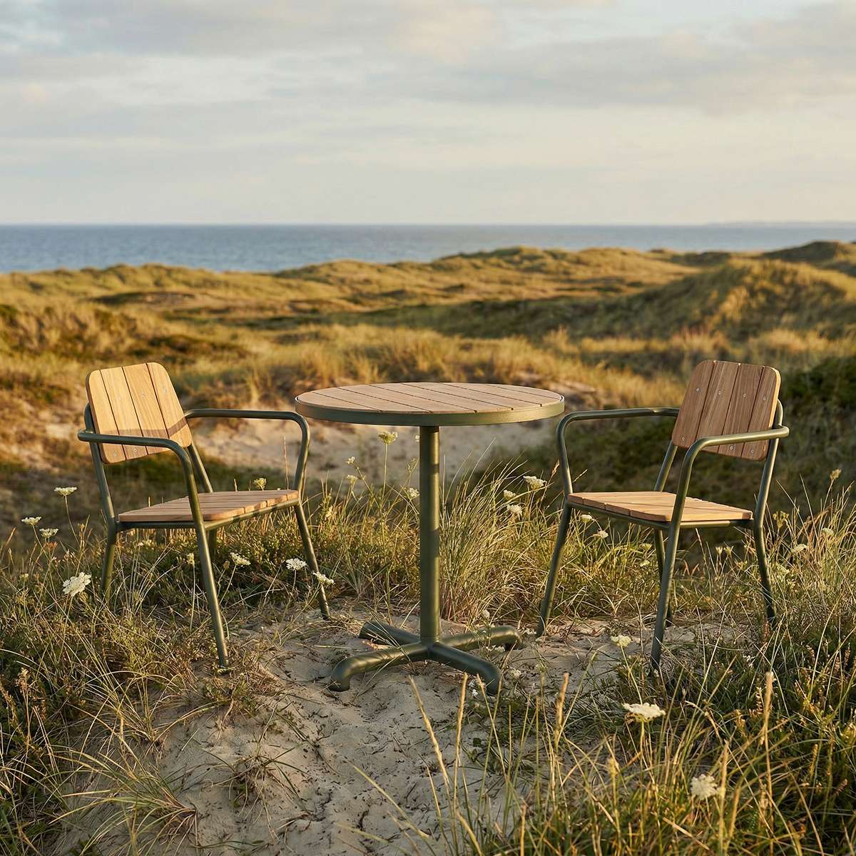 Kirra Café Table in olijfgroen van sackit in een ontspannen loungehoek buiten