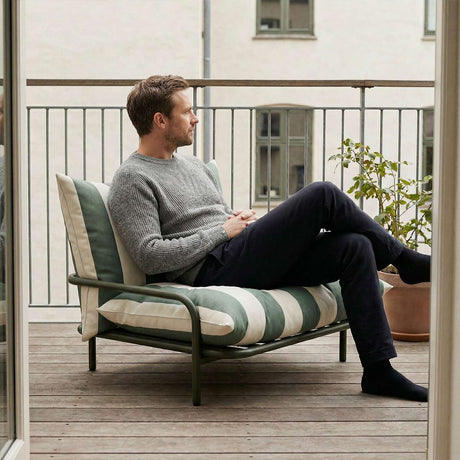 Mollis Lounge Chair in Renesse Olive van sackit op een terras