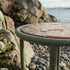 Mollis Side Table Ø50 in olijfgroen van sackit op een terras